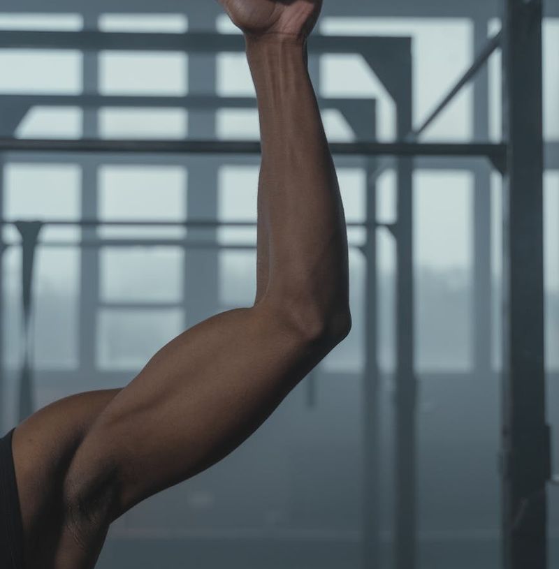 Close-up on a man's hands gripping a bar, showing muscle definition.